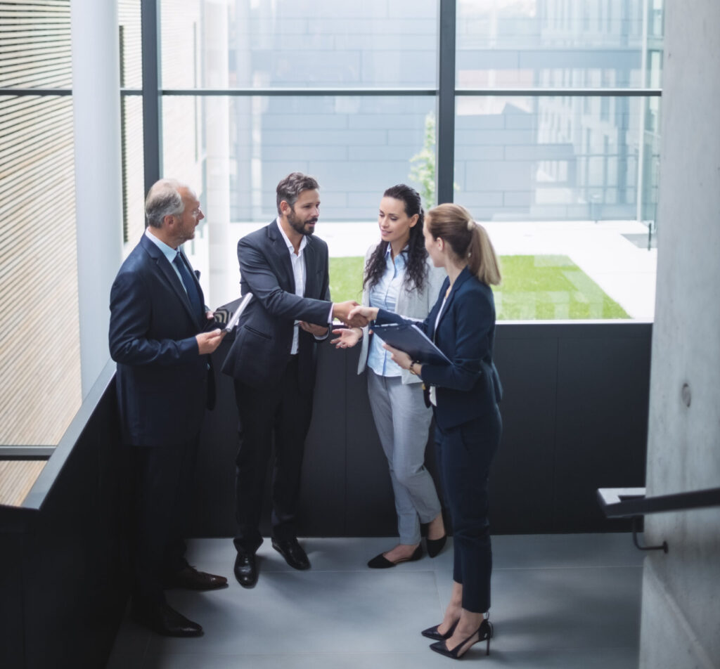 group of businesspeople having a discussion near staircase in office